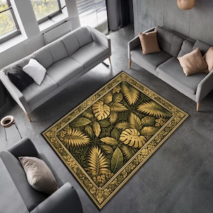 May include: A rectangular rug with a botanical design. It features large, stylized gold and green leaves on a dark background, with a decorative floral border. The rug is placed in a living room setting.