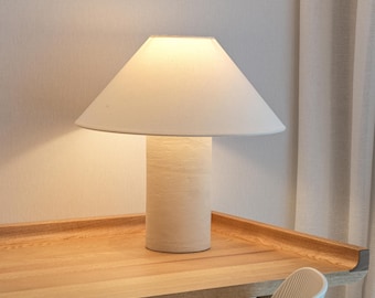 Handmade ceramic table lamp, a lighting and decorative object. Beige ceramic base and off-white canvas shade.