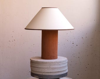 Handmade ceramic table lamp, a lighting and decorative object. Terracotta base and shade with brown trim.