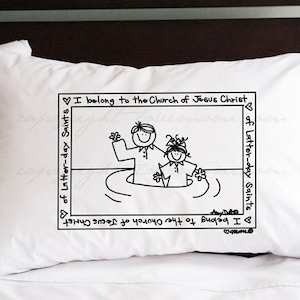 May include: White pillow with black text and a cartoon image of two people in water. The text reads "I belong to the Church of Jesus Christ of Latter-day Saints".