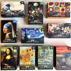 Könnte beinhalten: Eine Sammlung von neun Mini-Puzzleschachteln, jede mit einem anderen berühmten Kunstwerk. Die rechteckigen Schachteln zeigen Bilder von Gemälden wie Van Goghs "Sternennacht" und Hokusais "Die große Welle vor Kanagawa". Auf jeder Schachtel steht "mini JIGSAW PUZZLE".