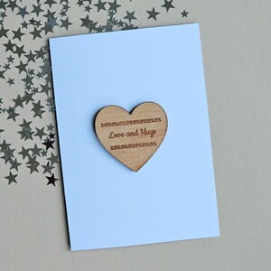 Gettone e biglietto a forma di cuore in legno con scritta "Amore e abbracci"