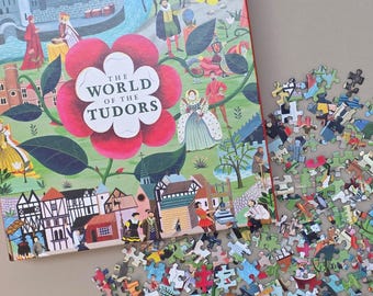 May include: A 1000-piece puzzle box with the title "The World of the Tudors" in a red flower design. The box shows illustrations of historical figures and buildings. Scattered puzzle pieces are visible.