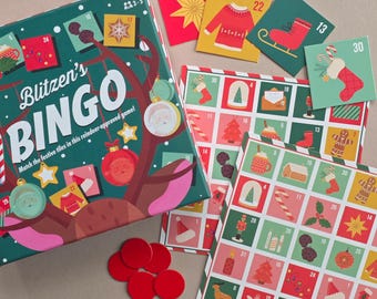 May include: A Christmas-themed Bingo game set. The box is green with the title "Blitzen's Bingo" and festive illustrations. Includes game cards, numbered tiles, and red markers. The game is designed for 2-6 players.