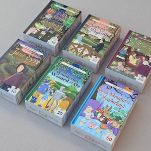May include: A selection of jigsaw puzzles with book cover designs from classic novels. The titles visible are "The Great Gatsby", "Pride & Prejudice", "Jane Eyre", "The Wonderful Wizard of Oz", "Little Women", and "Alice's Adventures in Wonderland."
