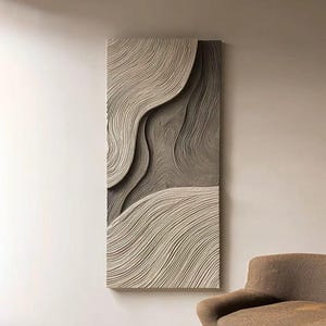 Può includere: Arte murale astratta con un design strutturato a strati, con motivi a onde. L'opera d'arte utilizza una tavolozza neutra di beige e grigio, creando un'estetica moderna e minimalista. Il pezzo rettangolare è montato su una parete.