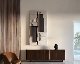 Puede incluir: Un interior moderno con un mueble de madera marrón oscuro con líneas verticales, una silla de cuero color canela y una escultura mural abstracta. Un jarrón negro descansa sobre el mueble. La habitación tiene una paleta de colores neutros, una alfombra y una vista de una piscina.