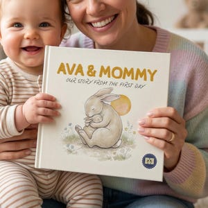 May include: A personalized book titled "AVA & MOMMY" with the subtitle "OUR STORY FROM THE FIRST DAY." The cover features a watercolor illustration of two rabbits, one embracing the other, set against a yellow sun and floral accents. The book is held by a person and a baby.