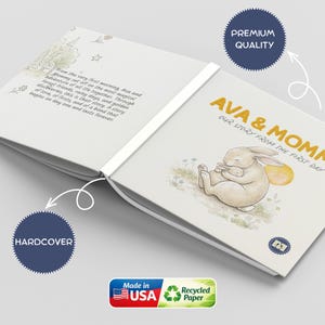 May include: A hardcover book titled "Ava & Mommy, Our Story From The First Day." The cover features an illustration of a mother rabbit and baby. The book is made in the USA with recycled paper. The book is labeled as premium quality.