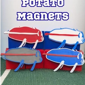 May include: Four Buffalo Bills potato magnets in red, white, gray, and blue, each featuring a horizontal stripe. The text reads BUFFALO BILLS POTATO MAGNETS and HIGH-QUALITY 3 X 1 1/2 INCH MAGNETS. The magnets are displayed on red and blue blocks.