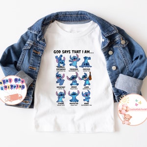 May include: White t-shirt with a blue Stitch character from the Disney movie Lilo & Stitch. The shirt features the text "God says that I am..." and lists several positive affirmations with corresponding Bible verses.