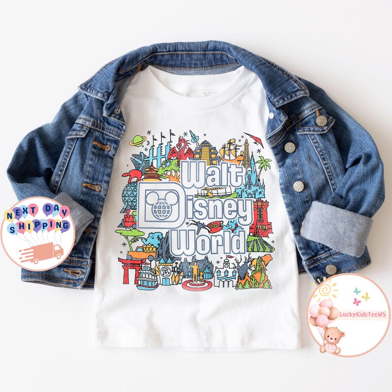 Pu&ograve; includere: Maglietta bianca con un'illustrazione colorata di vari monumenti di Disney World e il testo "Walt Disney World".