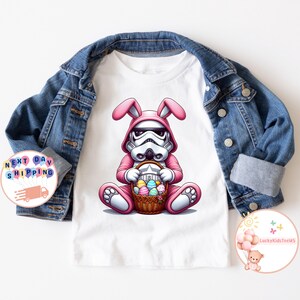 May include: White Easter bunny costume with pink ears and a white helmet. The bunny is holding a basket of colorful Easter eggs.