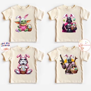 May include: Four cream colored t-shirts with different Star Wars characters wearing bunny ears and holding baskets of Easter eggs. The characters are Yoda, Darth Vader, Stormtrooper, and The Mandalorian.