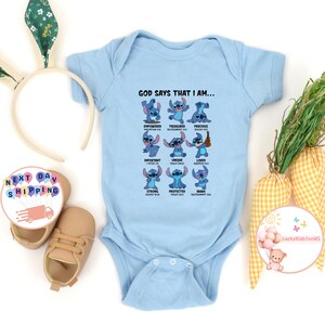 May include: Light blue baby onesie with a blue cartoon character and the text "GOD SAYS THAT I AM..." with a list of positive affirmations and bible verses.