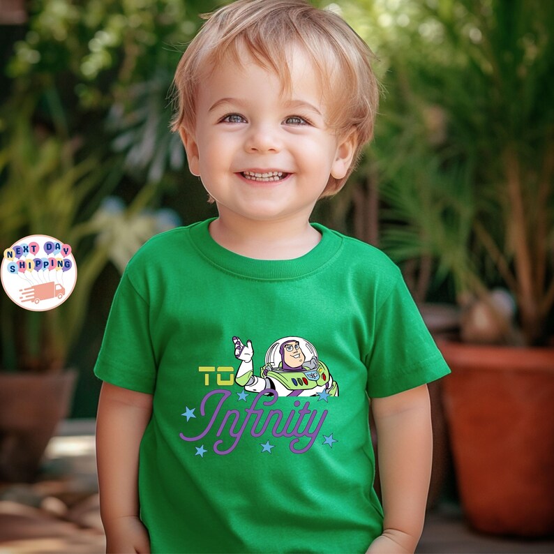 May include: A green t-shirt featuring Buzz Lightyear from Toy Story with the phrase "To Infinity" in purple and blue. The shirt is worn by a young child.