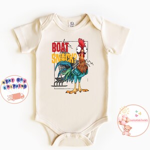 Peut inclure: Body b&eacute;b&eacute; cr&egrave;me avec un coq de dessin anim&eacute; et le texte "BOAT SNACKS" en rouge et jaune. Le coq a une cr&ecirc;te rouge, des plumes orange et marron, et des plumes de queue bleues et vertes.