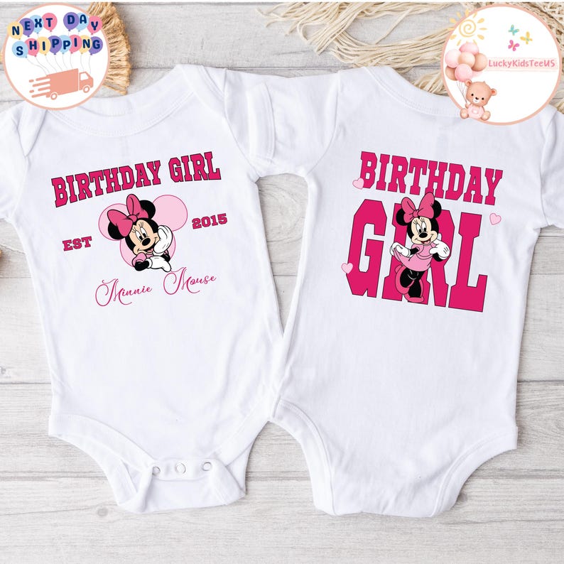 May include: Two white onesies with pink and red graphics. One onesie says "Birthday Girl Est 2015 Minnie Mouse" with a pink Minnie Mouse graphic. The other onesie says "Birthday Girl" with a pink Minnie Mouse graphic.