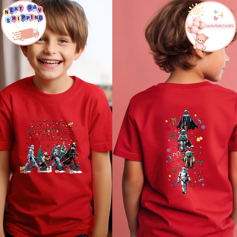 May include: Red t-shirt with Star Wars characters and text. The front design shows the Star Wars logo and characters with Christmas tree decorations. The back of the shirt displays Darth Vader, a Stormtrooper, and Yoda.