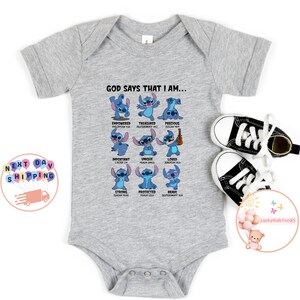 May include: Gray baby onesie with a blue Stitch character from the Disney movie Lilo & Stitch. The onesie has the text "God says that I am..." with a list of positive affirmations and bible verses.