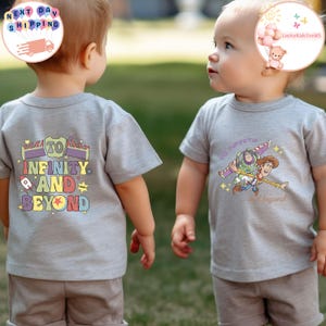 Puede incluir: Dos ni&ntilde;os con camisetas grises. Una camiseta presenta la frase "To Infinity and Beyond" con un dise&ntilde;o de cohete y estrella. La otra camiseta tiene un gr&aacute;fico de Buzz Lightyear y Woody. Ambas camisetas son de manga corta.