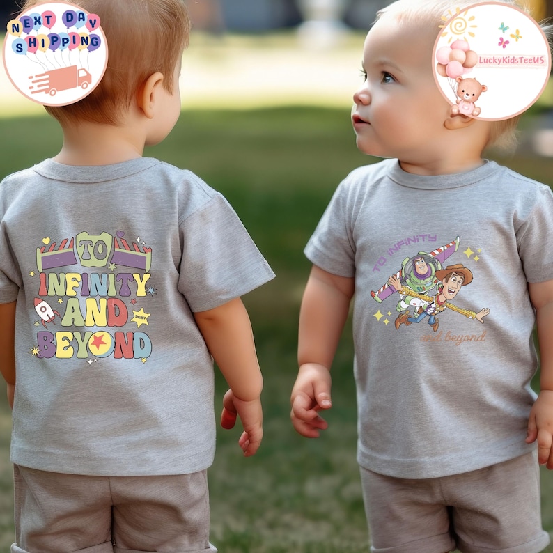Puede incluir: Dos ni&ntilde;os con camisetas grises. Una camiseta presenta la frase "To Infinity and Beyond" con un dise&ntilde;o de cohete y estrella. La otra camiseta tiene un gr&aacute;fico de Buzz Lightyear y Woody. Ambas camisetas son de manga corta.
