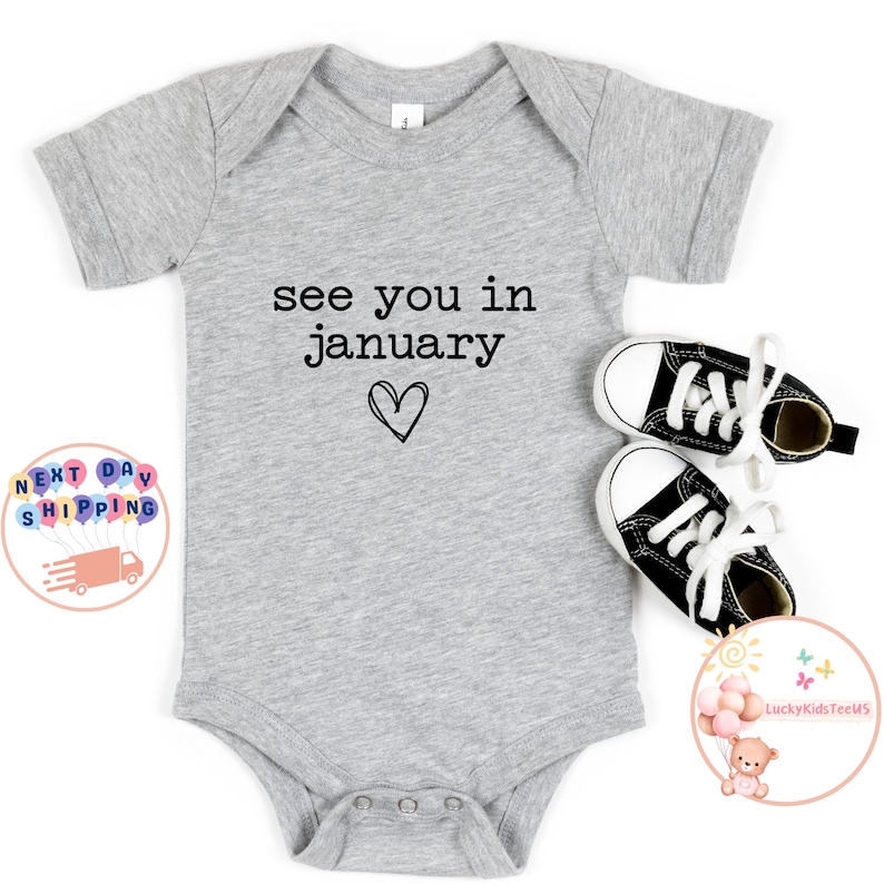May include: Gray baby onesie with the text "see you in january" and a small heart.