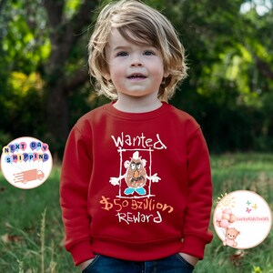 May include: Red sweatshirt with a white drawing of a cartoon character with the text "Wanted &pound;50 Billion Reward" on the front.