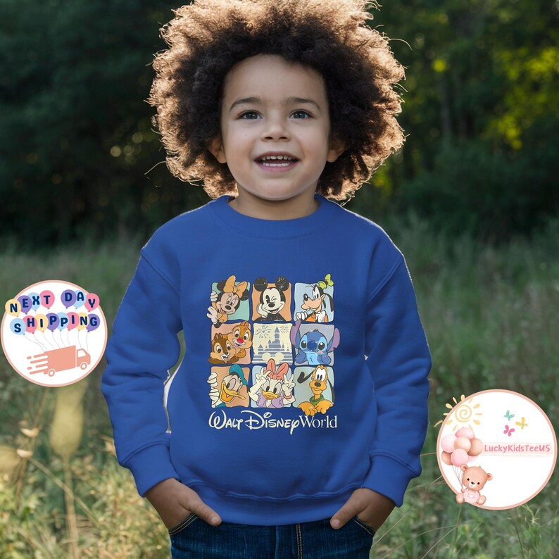 Puede incluir: Una sudadera azul real con una cuadr&iacute;cula de personajes de Disney, incluyendo Mickey Mouse, Donald Duck y Stitch. El texto "Walt Disney World" est&aacute; impreso debajo. La sudadera es usada por un ni&ntilde;o.