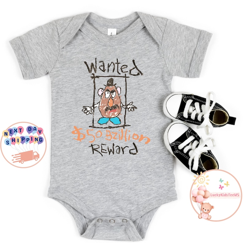 May include: A grey baby grow with a drawing of a cartoon potato head character with the text "Wanted &pound;50 Billion Reward".