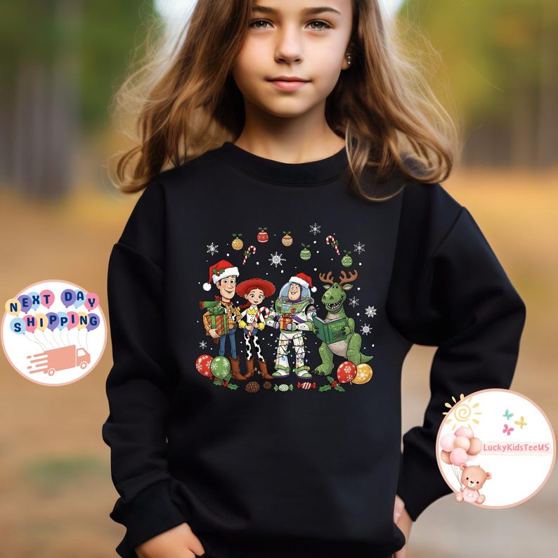May include: Black sweatshirt with a Christmas-themed Toy Story graphic. The design features Woody, Jessie, Buzz Lightyear, and Rex, all wearing Santa hats and holding presents. Festive decorations like candy canes and snowflakes are also included.