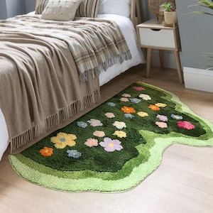 May include: A green and white area rug with a flower design. The rug is shaped like a butterfly and has a wavy edge.