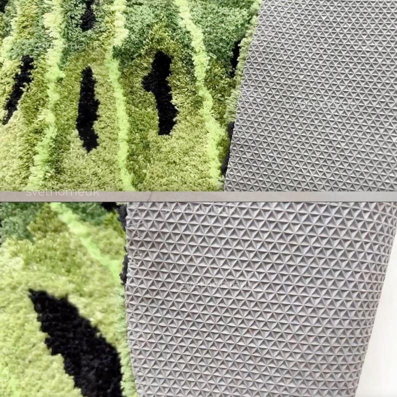 May include: A section of a green and black patterned rug with a textured surface. The rug's backing is a gray, geometric pattern. The rug is likely for home decor.