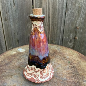 tall potion bottle with dripping pinks and blues
