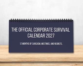 May include: A dark blue spiral-bound desk calendar with white text that reads THE OFFICIAL CORPORATE SURVIVAL CALENDAR 2027 and 12 MONTHS OF SARCASM, MEETINGS, AND REGRETS. The calendar is rectangular and features a black metal wire binding.