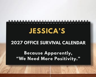 Könnte beinhalten: Ein schwarzer Schreibtischkalender mit Spiralbindung und weißem sowie gelbem Text: JESSICA'S 2027 OFFICE SURVIVAL CALENDAR Because Apparently, “We Need More Positivity.” Der Kalender hat ein rechteckiges Design mit schwarzer Drahtbindung.