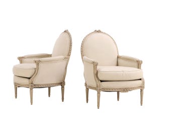 Coppia di poltrone bergère francesi dipinte in stile Luigi XVI con schienale ovale.