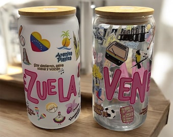 May include: Two glass beverage cups with bamboo lids. One cup is white with pink text and colorful stickers, the other is clear with pink text and various stickers. The text on the cups reads "VENEZUELA" and "VENE".