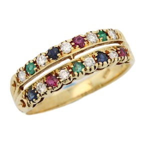 May include: A gold ring with two rows of gemstones. The ring features alternating white, green, red, and blue gemstones. The ring is set in a yellow gold band.
