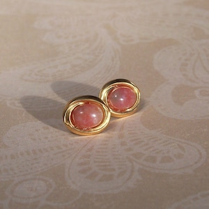 May include: A pair of gold tone earrings with pink stone cabochons.