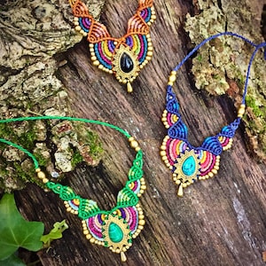Puede incluir: Tres collares de macramé con intrincados patrones de nudos en colores vibrantes. Cada collar incluye una piedra preciosa central en forma de lágrima, cuentas doradas y cordones finos. Los diseños muestran paletas de colores naranja, azul y verde.