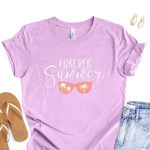 May include: A light purple t-shirt with the words "FOREVER Summer" in white script and a pair of orange sunglasses with palm trees. The shirt is paired with denim shorts, gold earrings, and brown flip-flops.