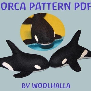 May include: A PDF pattern for sewing a plush orca, featuring two black and white orcas with white bellies and black eyes. The pattern is by Woolhalla.