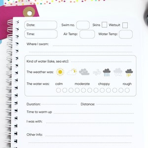 May include: A white log book with a black and gray design. The book has sections for recording swim details, including date, time, swim number, air temperature, water temperature, kind of water, weather conditions, water conditions, duration, distance, time to warm up, who you were with, other information, and notes.