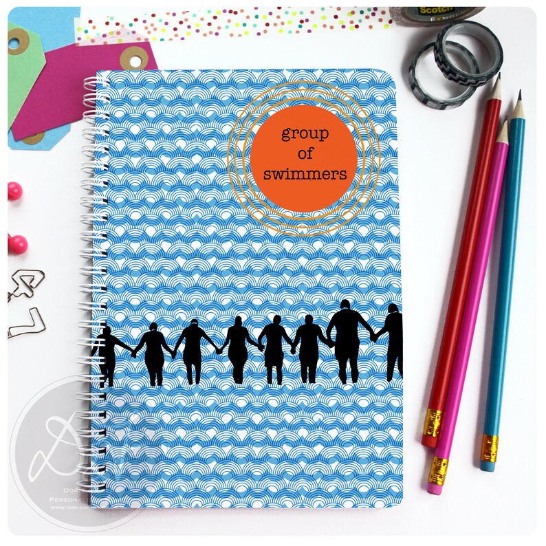 May include: A blue and white spiral notebook with a pattern of waves. The cover features a silhouette of a group of people holding hands, with the text "group of swimmers" in a circle.