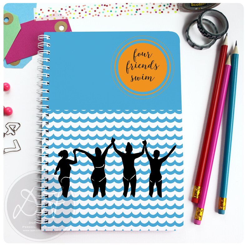 May include: A blue spiral notebook with a white and blue wave pattern. The cover features a circle with the text "four friends swim" in orange and gold. Four black silhouettes of people holding hands are swimming in the waves.