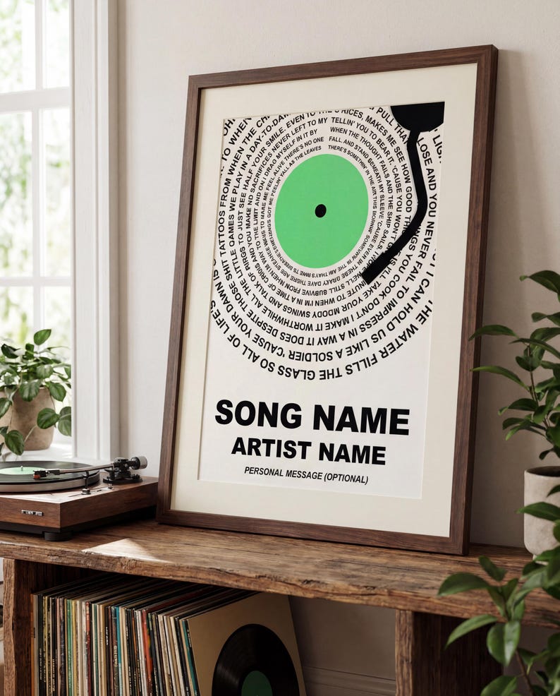 May include: Framed print featuring a vinyl record design with a green center and black details. The artwork includes song lyrics and space for a song name, artist name, and a personal message. The frame is a dark brown color.