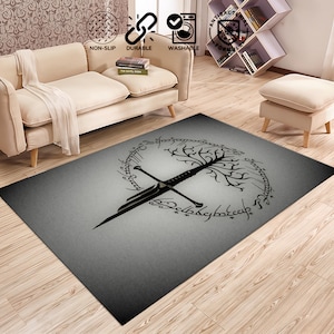 Puede incluir: Una alfombra rectangular gris con un diseño de espada negra, árbol y escritura. La alfombra es duradera y lavable. El diseño está centrado en la alfombra, con un fondo degradado.