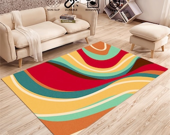 May include: Abstract area rug with a colorful design of wavy lines in shades of red, yellow, orange, brown, blue, and green. The rug is on a wooden floor.
