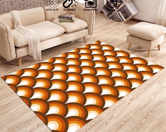 Puede incluir: Una alfombra marrón y naranja con un patrón geométrico de semicírculos superpuestos. La alfombra tiene un fondo blanco.